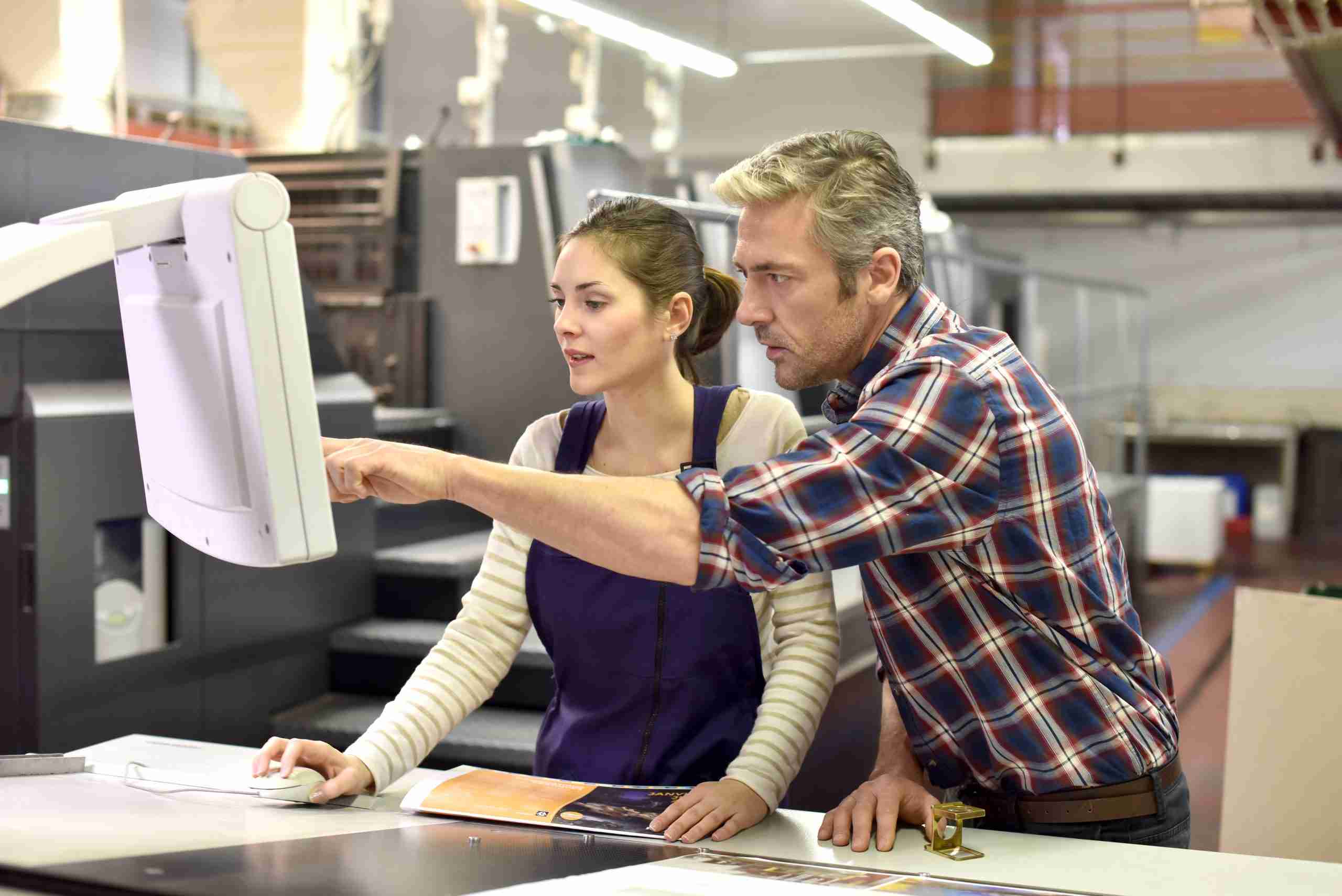 Man working with apprentice in printing house